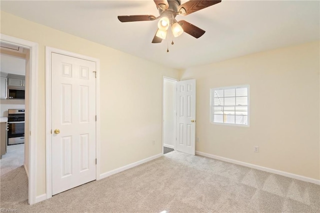 unfurnished bedroom featuring ceiling fan and light colored carpet