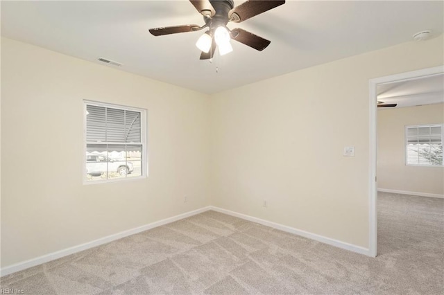 carpeted empty room featuring plenty of natural light and ceiling fan