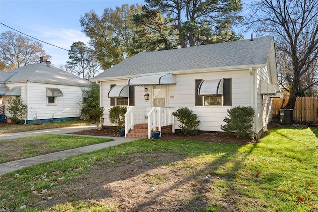 view of front of property with central air condition unit and a front lawn