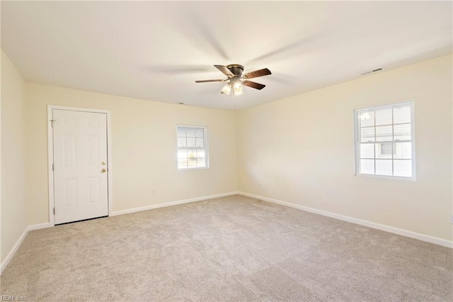 spare room featuring light colored carpet, plenty of natural light, and ceiling fan