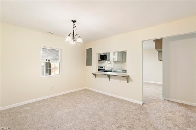 carpeted empty room featuring electric panel and an inviting chandelier