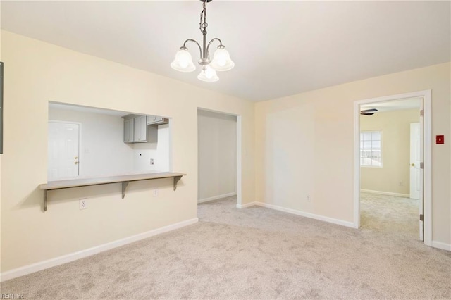 unfurnished living room featuring light colored carpet and a chandelier