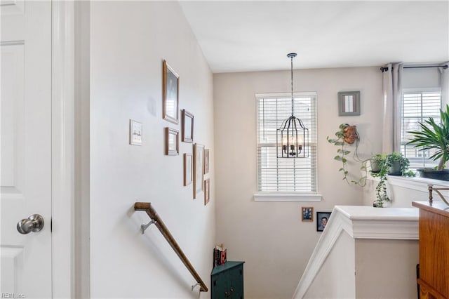 staircase with an inviting chandelier