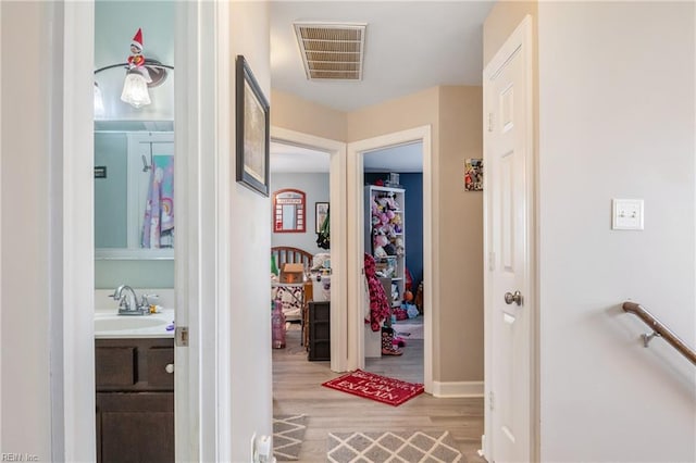 corridor featuring light hardwood / wood-style floors and sink