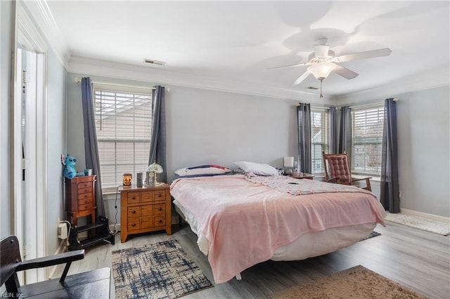 bedroom with ceiling fan, light hardwood / wood-style floors, and ornamental molding