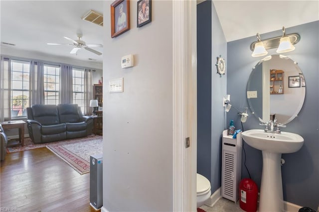 bathroom featuring ceiling fan, hardwood / wood-style floors, sink, and toilet