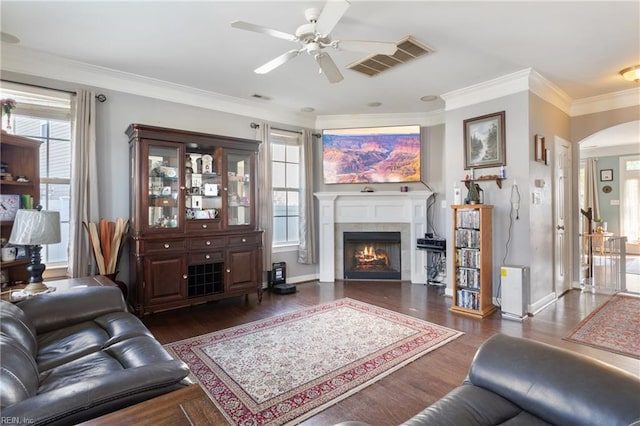 living room with crown molding, ceiling fan, and dark hardwood / wood-style floors