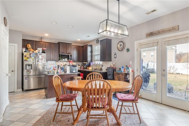 dining space featuring a healthy amount of sunlight, light tile patterned flooring, and french doors