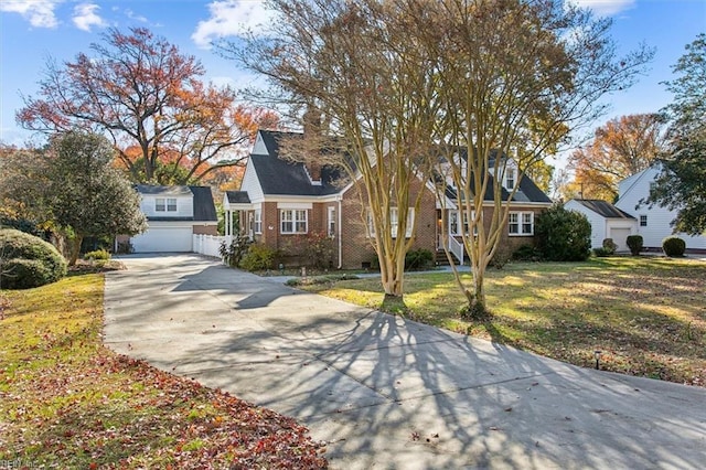 cape cod house with a garage and a front lawn