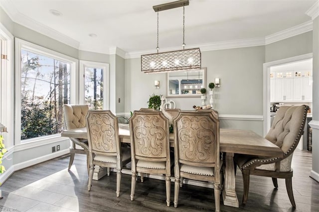 dining space with hardwood / wood-style floors, a healthy amount of sunlight, and ornamental molding