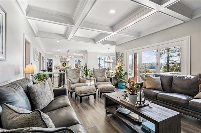 living room featuring coffered ceiling, hardwood / wood-style flooring, ornamental molding, beamed ceiling, and a chandelier