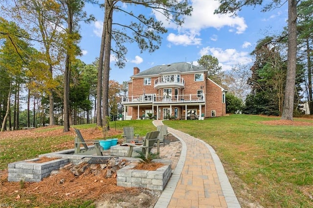 back of property with a deck, a fire pit, a patio area, and a lawn