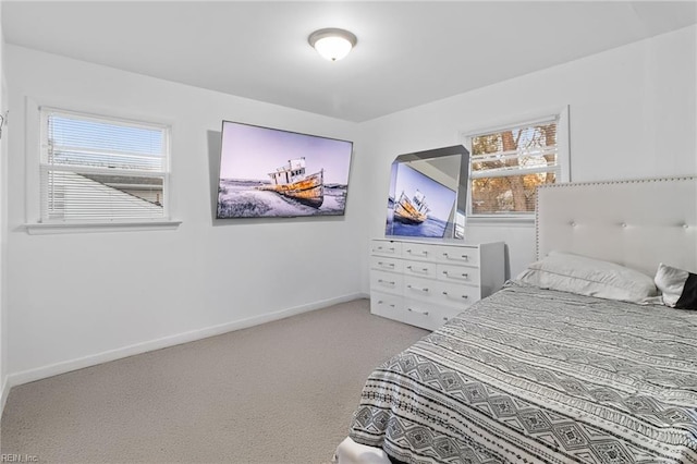 bedroom with light carpet and multiple windows