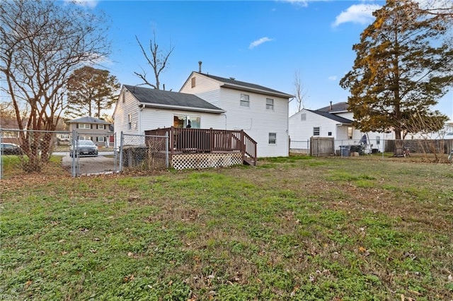 rear view of house with a yard and a wooden deck