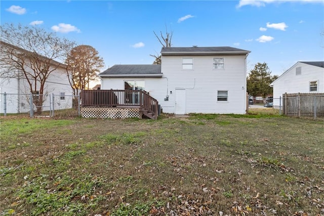 back of property featuring a lawn and a wooden deck