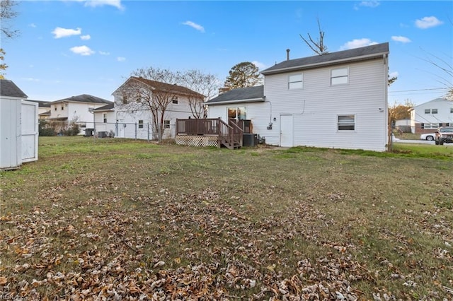 back of house featuring a deck, a yard, and central air condition unit