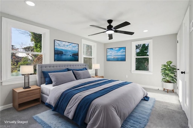 bedroom featuring multiple windows, ceiling fan, and light colored carpet