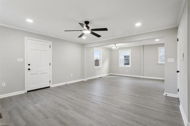 unfurnished room featuring hardwood / wood-style floors, ceiling fan with notable chandelier, and crown molding