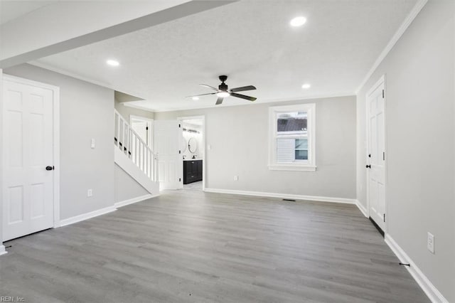 unfurnished living room with hardwood / wood-style floors, ceiling fan, and ornamental molding