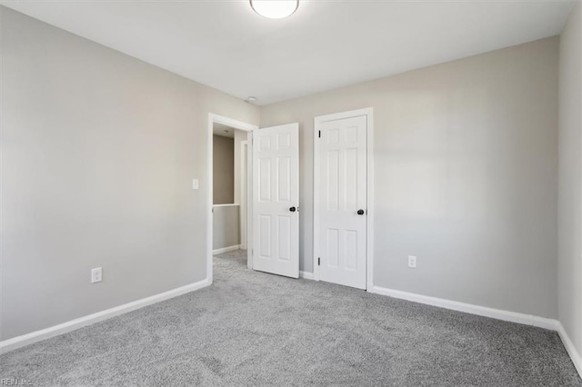 unfurnished bedroom featuring light carpet and a closet