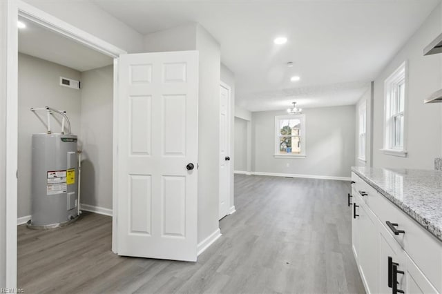 hallway featuring light hardwood / wood-style floors and water heater