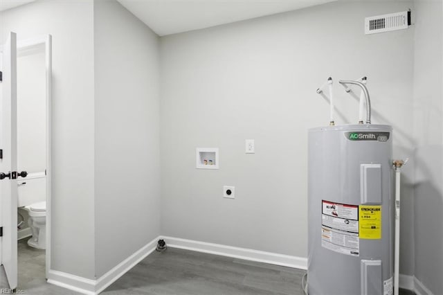 laundry area with electric dryer hookup, electric water heater, dark wood-type flooring, and hookup for a washing machine