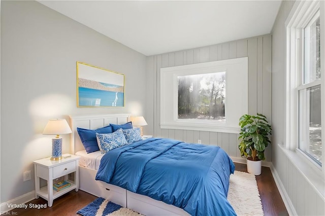 bedroom with multiple windows and dark wood-type flooring