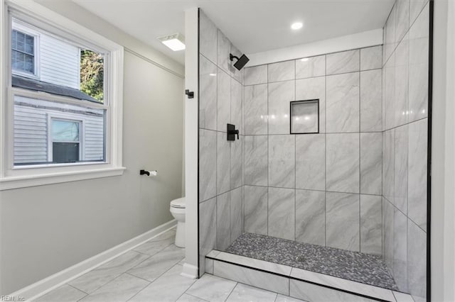 bathroom featuring toilet and tiled shower