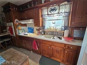 kitchen with light tile patterned floors, sink, and exhaust hood