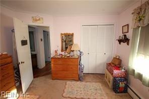 bedroom featuring a baseboard heating unit and a closet