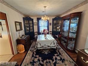 dining room featuring hardwood / wood-style flooring, plenty of natural light, ornamental molding, and a notable chandelier