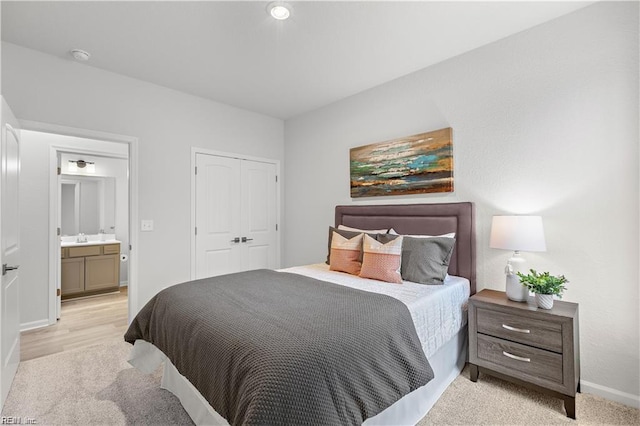 carpeted bedroom with ensuite bath and a closet