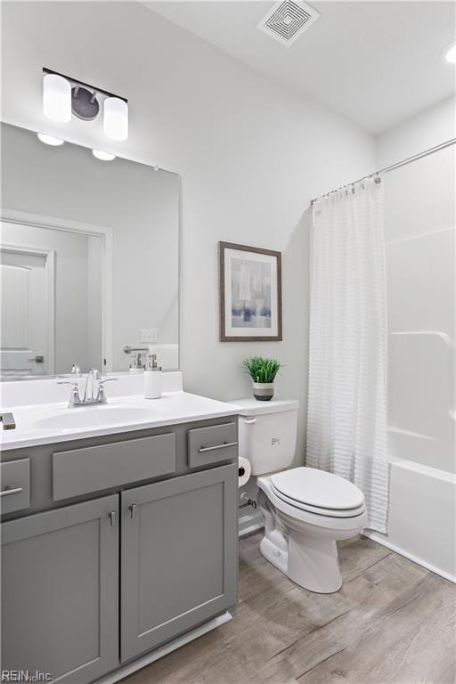 full bathroom featuring shower / bath combo with shower curtain, vanity, wood-type flooring, and toilet