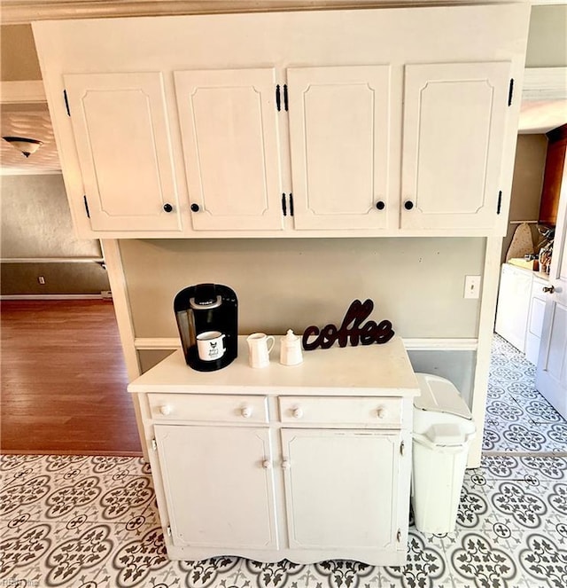 kitchen with white cabinets, washer / dryer, and light wood-type flooring