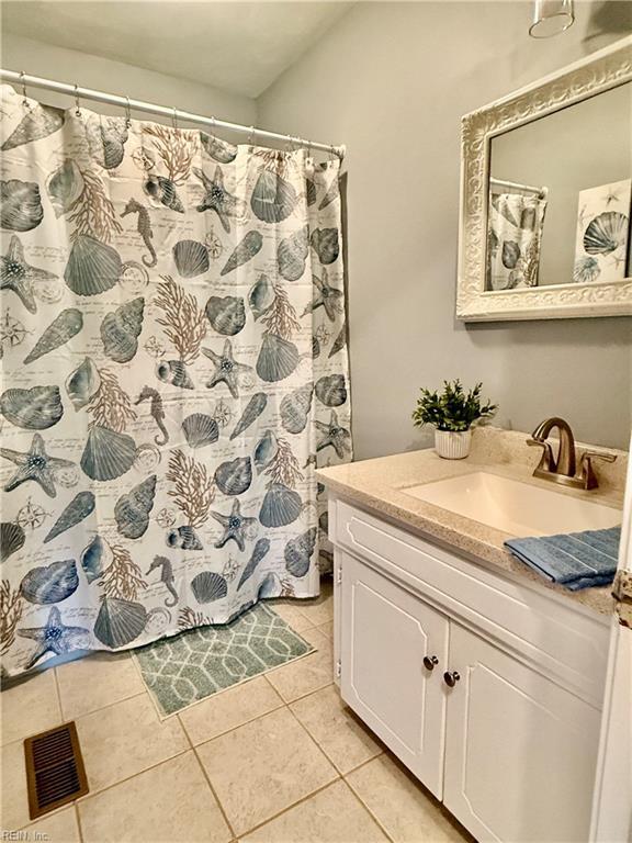 bathroom with tile patterned floors, vanity, and a shower with shower curtain