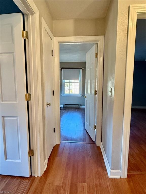 hallway with baseboard heating and hardwood / wood-style flooring