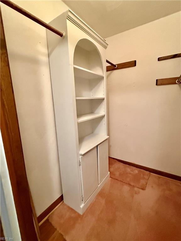 walk in closet featuring light carpet