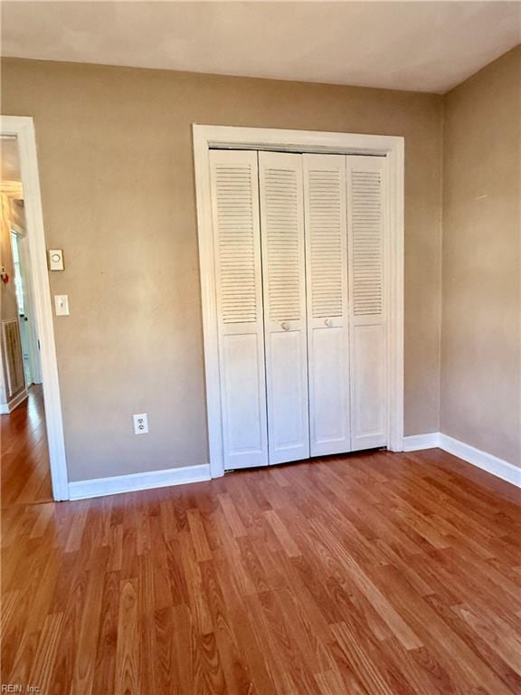 unfurnished bedroom with hardwood / wood-style floors and a closet