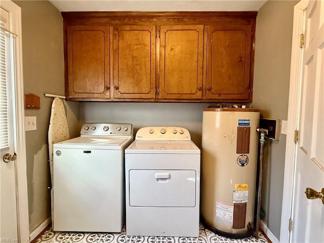 laundry area with cabinets, washing machine and clothes dryer, and water heater