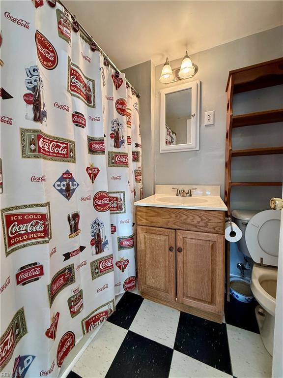 bathroom featuring vanity, toilet, and walk in shower