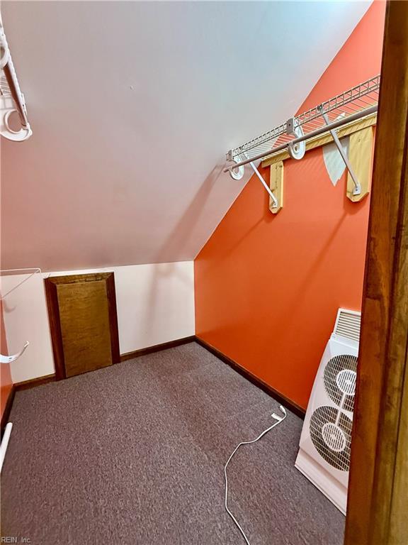 walk in closet with carpet flooring, ac unit, and lofted ceiling