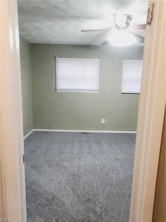 spare room featuring ceiling fan and carpet