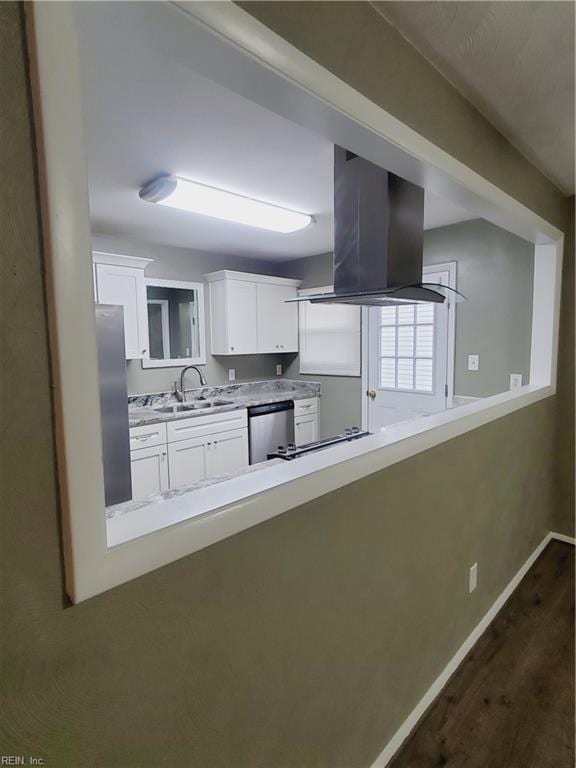 kitchen with appliances with stainless steel finishes, dark hardwood / wood-style flooring, extractor fan, sink, and white cabinets