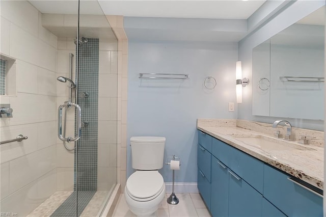 bathroom featuring tile patterned floors, vanity, a shower with shower door, and toilet