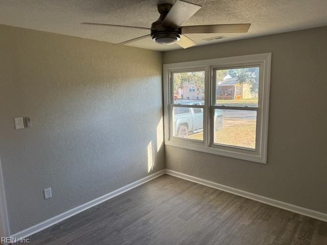 empty room featuring ceiling fan, dark hardwood / wood-style floors, and a textured ceiling