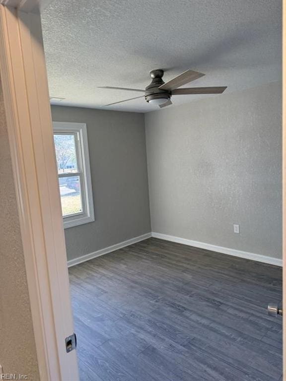 unfurnished room with ceiling fan, dark hardwood / wood-style flooring, and a textured ceiling