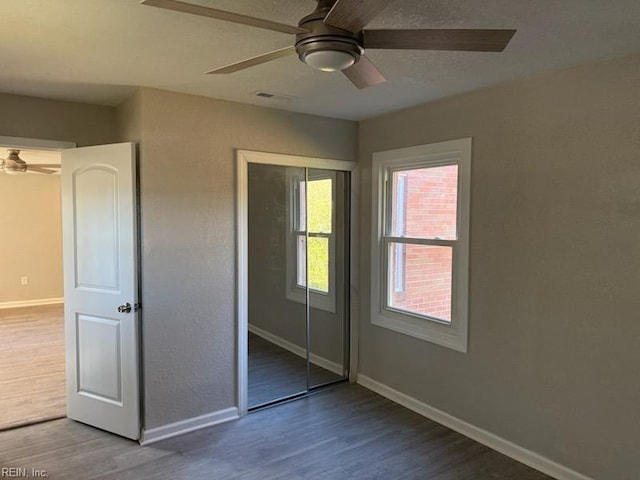 unfurnished bedroom featuring ceiling fan, hardwood / wood-style floors, and a closet