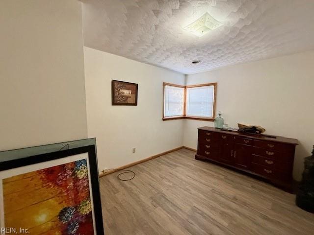 interior space featuring a textured ceiling and light wood-type flooring