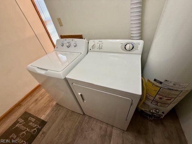 clothes washing area featuring wood-type flooring and washing machine and dryer