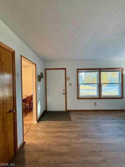 foyer entrance with hardwood / wood-style floors and a textured ceiling